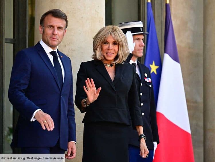 Brigitte Macron chic dans un tailleur noir moderne - on adore cet accessoire tendance qui apporte du style à sa tenue